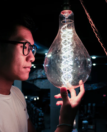 Photo of man looking at inventive light bulb