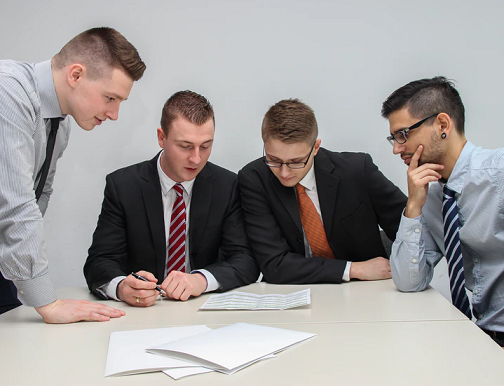 Colour photo of skilled workers at a desk in an office