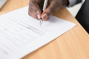 Image of hand signing a contract